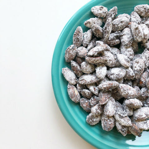 Coffee crusted almonds on an aqua plate