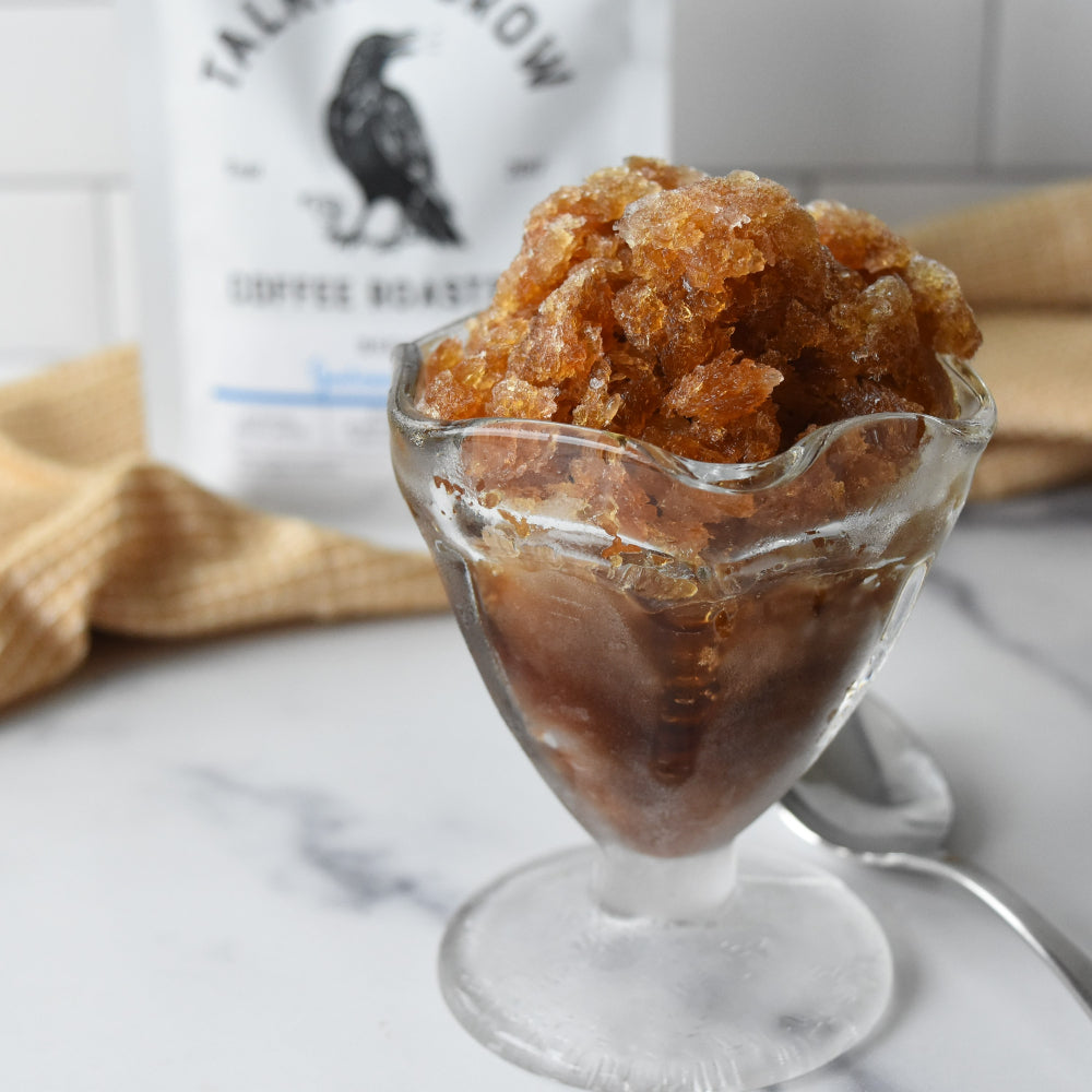 Coffee granita in a dessert glass with a 12 oz. bag of Talking Crow Coffee Roasters decaf Guatemala in the background
