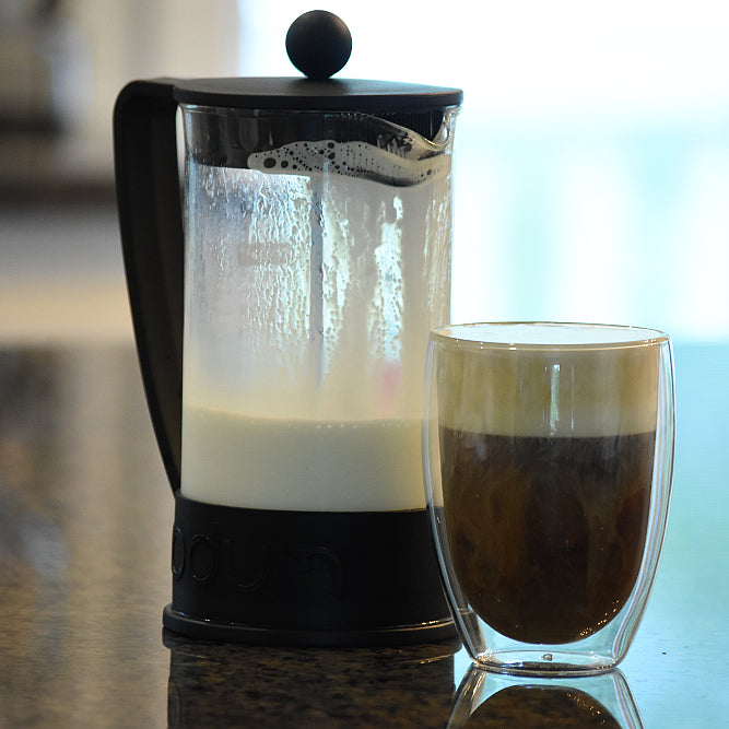 French press with glass of coffee with cold foam