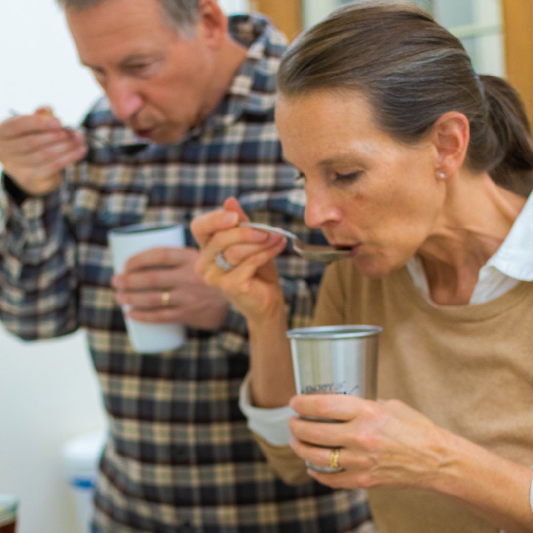 A man and woman cupping specialty coffee at Talking Crow Coffee Roasters