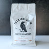 White coffee bag with 'Talking Crow Coffee Roasters' branding on a dark background