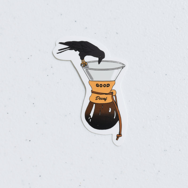 Crow on the edge of a Chemex brewer with collar that says Good Decaf die cut sticker